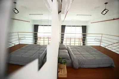 two beds in a large room with windows at Private 100 inches Screen Cinema at CEO Penang in Bayan Lepas