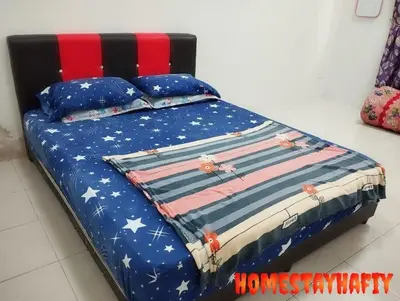 a bed with an american flag blanket and pillows at Homestay Hafiy Manjung Lekir Sitiawan in Lekir