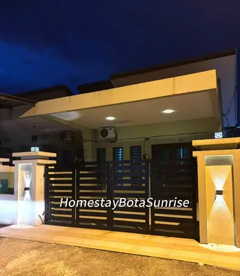 a fence in front of a house at night at Homestay Bota Sunrise in Kampung Bota Kiri