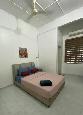 a bedroom with a large bed with red and blue pillows at Nur Kasih Homestay Seri Manjung in Seri Manjung