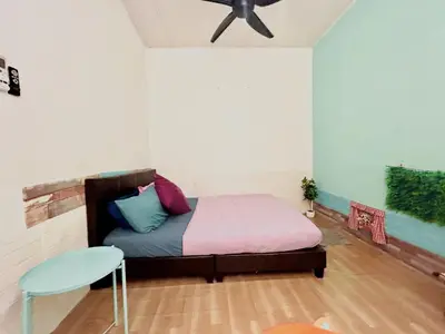 a bedroom with a bed and a table and a fan at Cozy16#4pax#wifi#NearAeonAlma#5kmtoiconcity in Bukit Mertajam