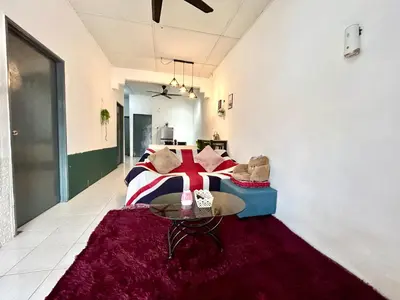 a bedroom with a bed and a table on a rug at Cozy16#4pax#wifi#NearAeonAlma#5kmtoiconcity in Bukit Mertajam