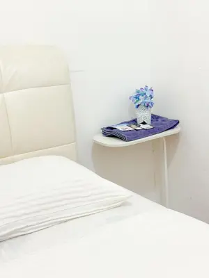 a bed and a table with a potted plant on it at Tonight Hotel in George Town