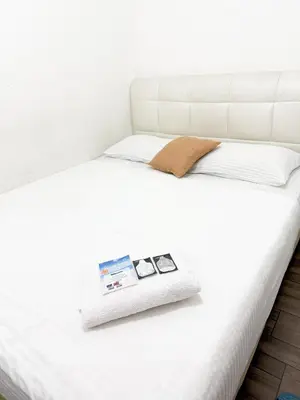 a white bed with a picture frame on it at Tonight Hotel in George Town