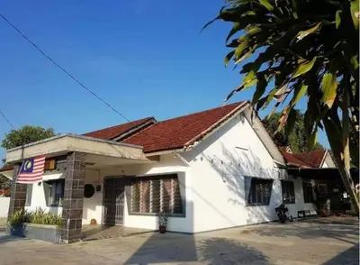 a white house with an american flag on it at Raintown inn taiping in Taiping