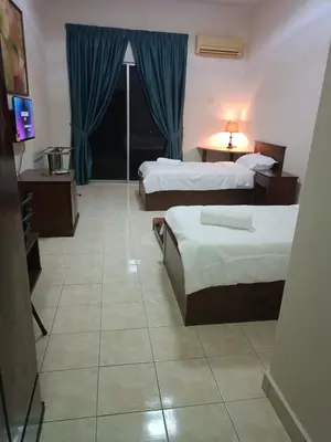 a hotel room with two beds and a television at Sofea Inn Bukit Merah - Suria A7727 in Kampong Selemat
