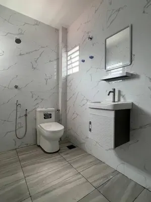 a bathroom with a toilet and a sink and a mirror at One's Homestay in Seri Manjung