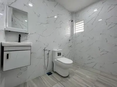 a white bathroom with a toilet and a sink at One's Homestay in Seri Manjung