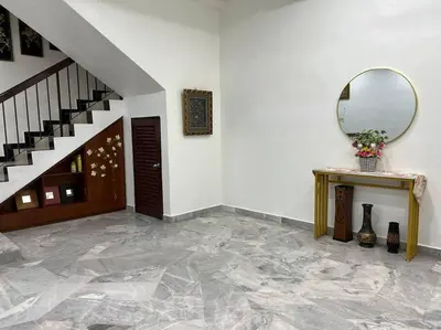 a hallway with a staircase and a mirror and a table at One's Homestay in Seri Manjung