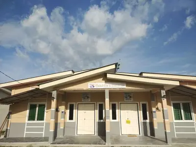 a building with white doors and a cloudy sky at Homestay Embah Ros & Embah Lek in Hutan Melintang
