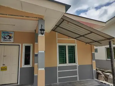 a house with a porch and a garage at Homestay Embah Ros & Embah Lek in Hutan Melintang