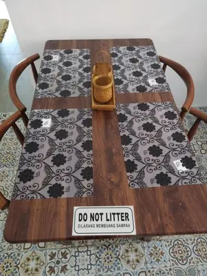 a wooden table with a sign that says do not litter at Homestay Embah Ros & Embah Lek in Hutan Melintang
