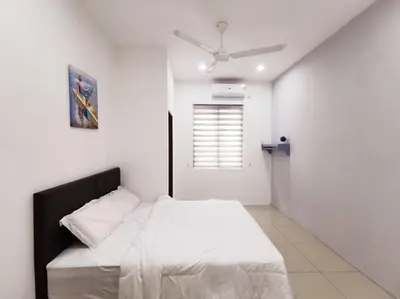 a bedroom with a bed with white sheets and a ceiling fan at Botani Tmn Cyber Ipoh(24 pax /tv box/mahjong) in Ipoh