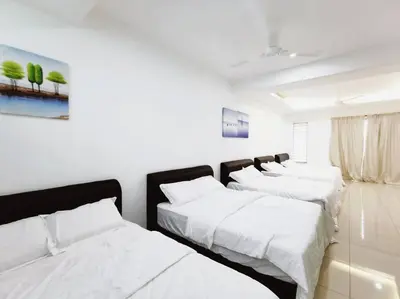three beds in a room with white walls at Botani Tmn Cyber Ipoh(24 pax /tv box/mahjong) in Ipoh