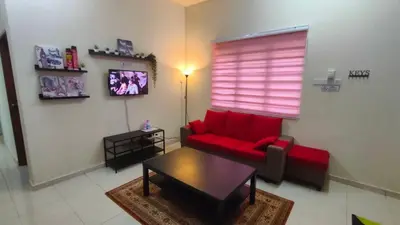 a living room with a red couch and a table at Che Det Homestay Chemor in Chemor