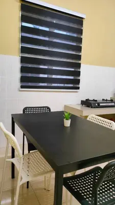 a dining room table with chairs and a window at Che Det Homestay Chemor in Chemor