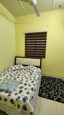 a bedroom with a bed and a window and a rug at Che Det Homestay Chemor in Chemor