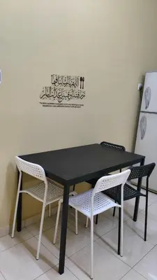 a black table with two chairs and a refrigerator at Che Det Homestay Chemor in Chemor