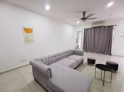 a living room with a couch and a table and chairs at Bdr Seri Botani ipoh-nordic (tvbox/mahjong 19pax) in Ipoh
