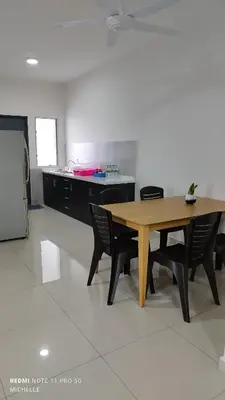 a kitchen with a wooden table and black chairs at Spaces 3bed Room New Condo @ Kg Paloh Ipoh in Ipoh