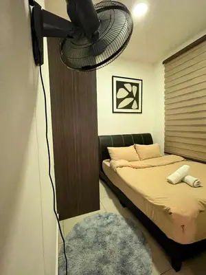 a bedroom with a bed and a fan at Paddy Bee in Brinchang
