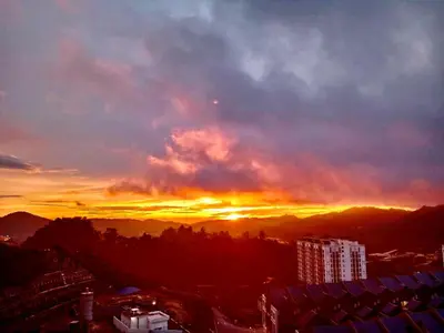 a sunset over a city with the sun setting at Paddy Bee in Brinchang
