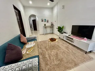 a living room with a blue couch and a flat screen tv at Cozy288#4pax#wifi#NearAeonAlma,Mcd#2kmtoIconicPoint in Bukit Mertajam