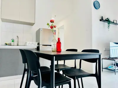 a black table with chairs and a vase with flowers at The Sun 1 or 3BR Bayan Lepas 4 to 10 pax WL in Bayan Lepas