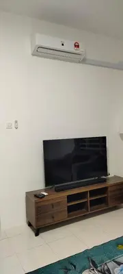 a flat screen tv sitting on top of a entertainment center at Homestay Millazzz Apparment Ipoh in Kampong Duson Gilap