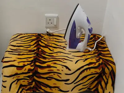 a bed with a computer on top of a tiger print sheets at Homestay Millazzz Apparment Ipoh in Kampong Duson Gilap