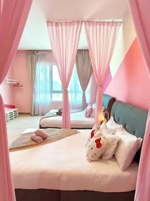 a bedroom with two beds with pink walls and curtains at PoP Kitty Octagon Premium Ipoh Town Center 2BR by Grab A Stay in Ipoh