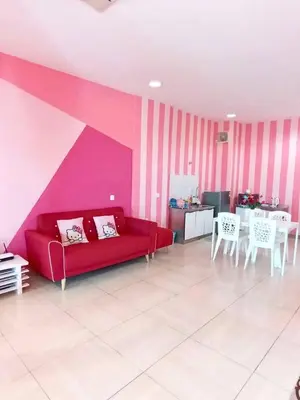 a living room with a red couch and a pink wall at PoP Kitty Octagon Premium Ipoh Town Center 2BR by Grab A Stay in Ipoh