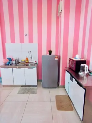 a kitchen with a sink and a refrigerator at PoP Kitty Octagon Premium Ipoh Town Center 2BR by Grab A Stay in Ipoh
