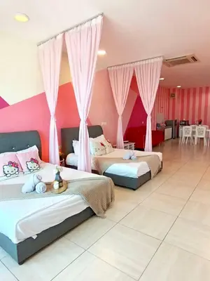 two beds in a large room with pink walls at PoP Kitty Octagon Premium Ipoh Town Center 2BR by Grab A Stay in Ipoh