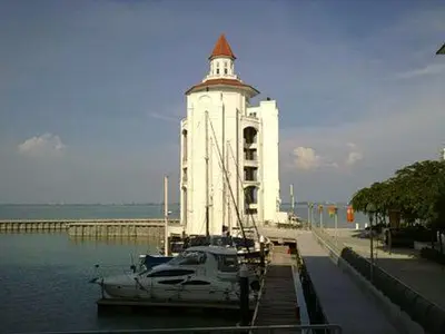 a boat in the water next to a building at Perfect Marina Stay @ Strait Quay 6 Pax Max in Bagan Jermal