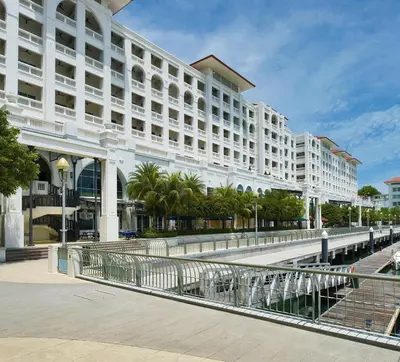 a large white building with palm trees in front of it at Perfect Marina Stay @ Strait Quay 6 Pax Max in Bagan Jermal
