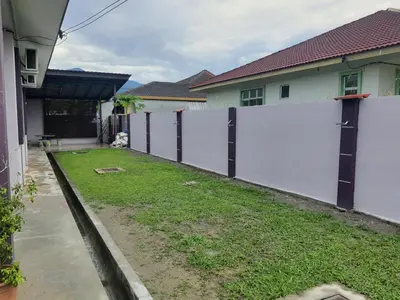 a white fence in front of a yard with houses at KS Villa Homestay Kuala Kubu Bharu in Kampong Peruntun