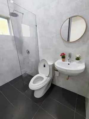 a bathroom with a toilet and a sink and a mirror at Ipoh Lake View Cozy Home Big House in Lahat