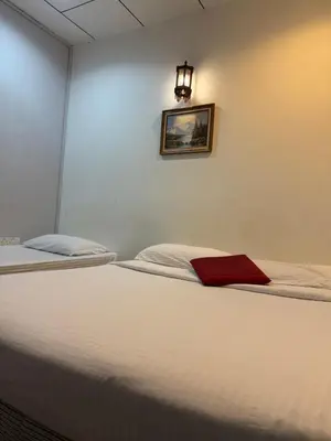 a bedroom with a bed with a red towel on it at G99 Hotel in George Town