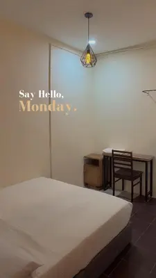 a bedroom with a bed and a table and a chair at G99 Hotel in George Town