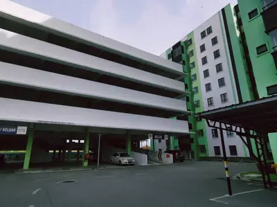 a green and white building with a car parked in a parking lot at Ipoh Manhattan waterpark safari-12pax(projector) in Ipoh