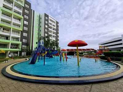 a pool with a playground with a slide and an umbrella at Ipoh Manhattan waterpark safari-12pax(projector) in Ipoh
