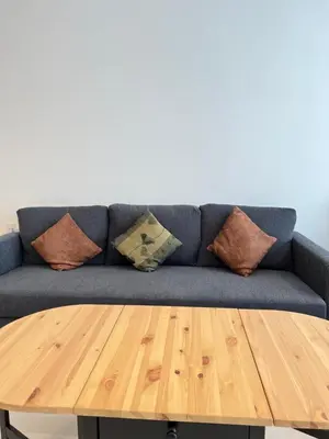 a blue couch with pillows and a wooden table at Beacon Executive Suites #Georgetown #RoofTopPool #Spacious #13a in George Town