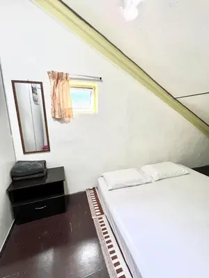a small bedroom with a bed and a mirror at De Cameron Guest House in Tanah Rata