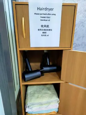 a wooden cabinet with a hair dryer in it at 678 homestay 4 room 5 minutes to tower in Teluk Intan