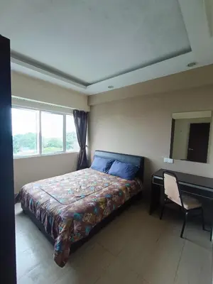 a bedroom with a bed and a desk and window at Lovers Island homestay in Batu Ferringhi