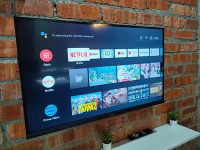 a flat screen tv hanging on a brick wall at Studio Amani 1 Permatang Pauh in Permatang Pauh