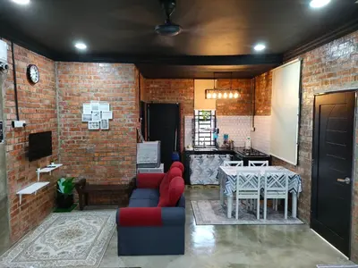 a living room with a table and a brick wall at Studio Amani 1 Permatang Pauh in Permatang Pauh