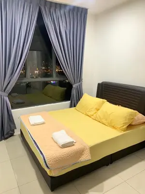 a bedroom with a bed with yellow sheets and a window at SM Homestay @ Meru Casa Kayangan in Ipoh