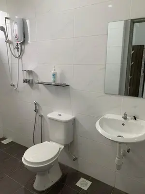 a white bathroom with a toilet and a sink at SM Homestay @ Meru Casa Kayangan in Ipoh